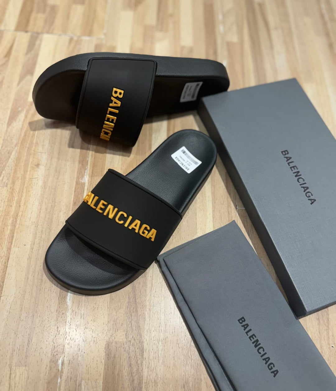 Flat slides in black rubber embossed with the Balenciga logo in gold - uaessss