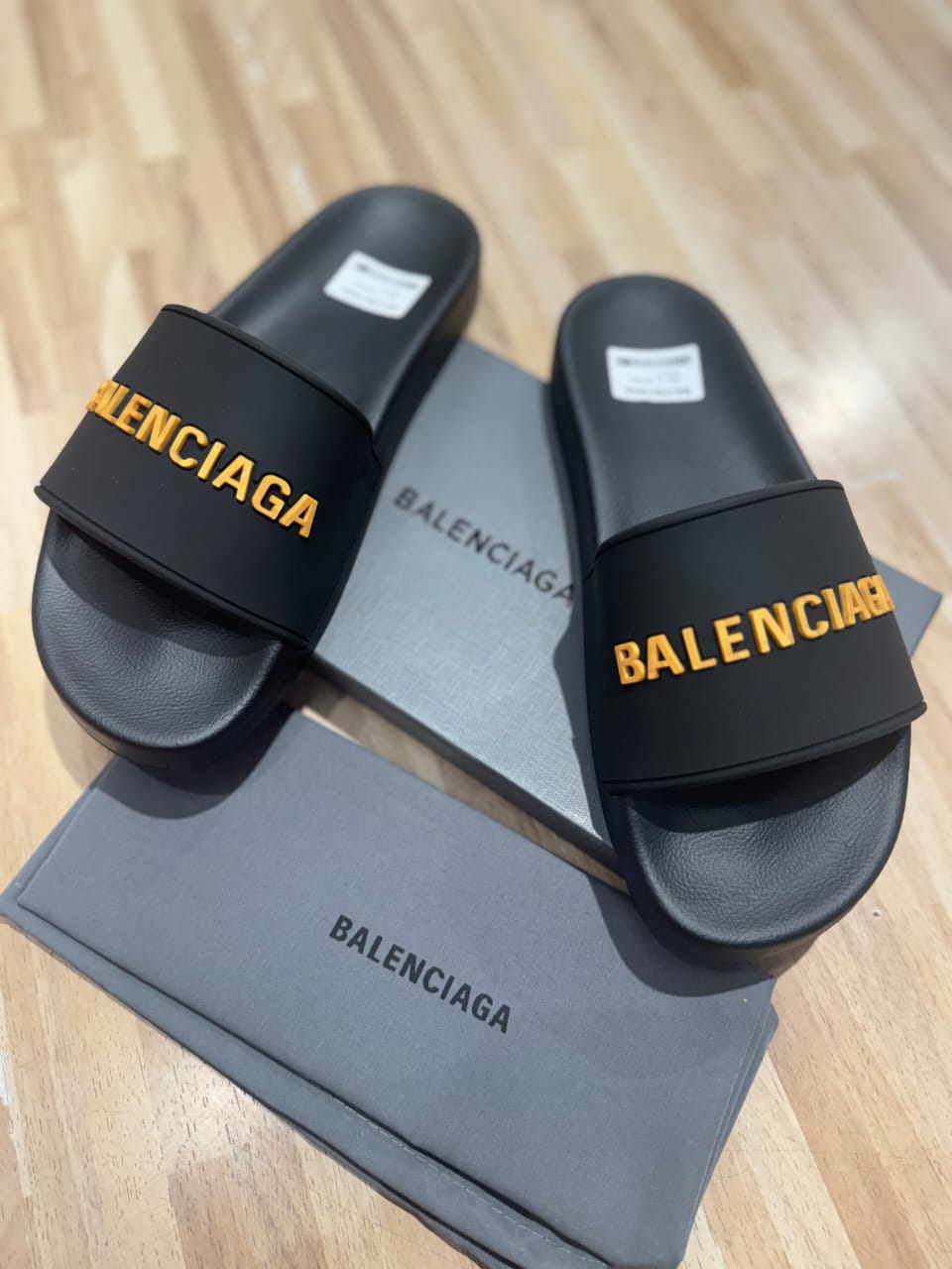 Flat slides in black rubber embossed with the Balenciga logo in gold - uaessss